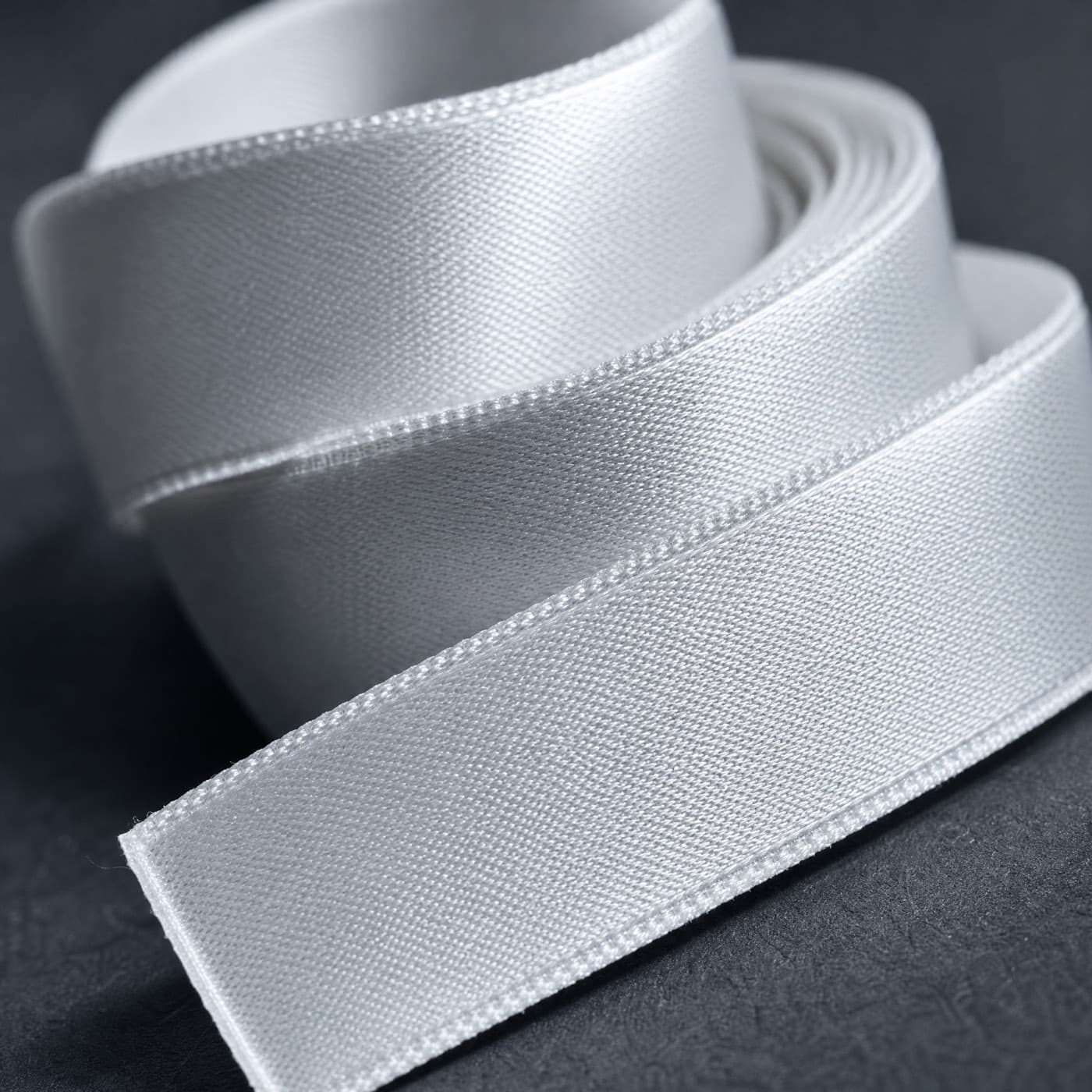 A coiled blank woven label ribbon, photographed close up