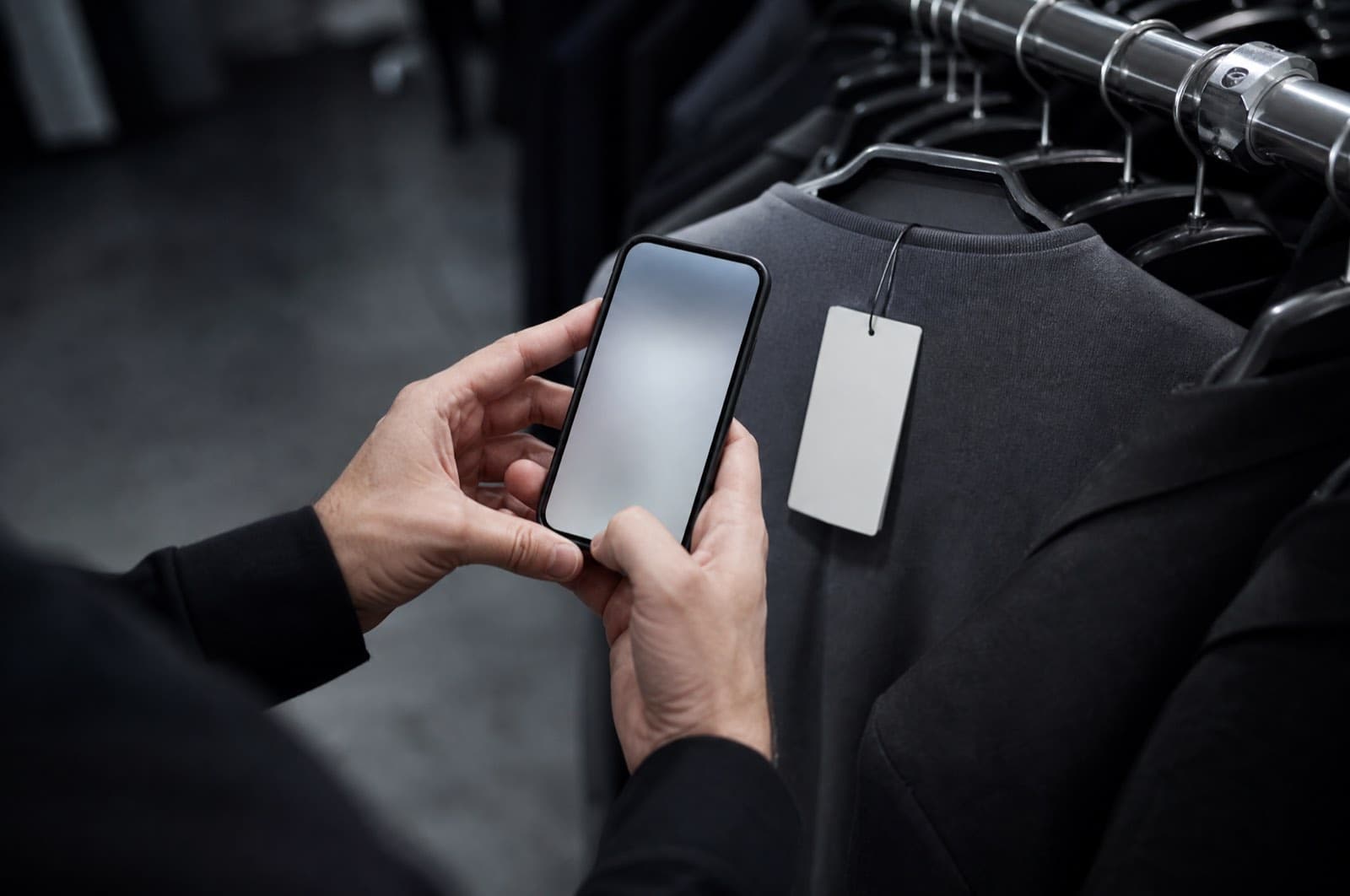 A hangtag on a garment being photographed with a phone